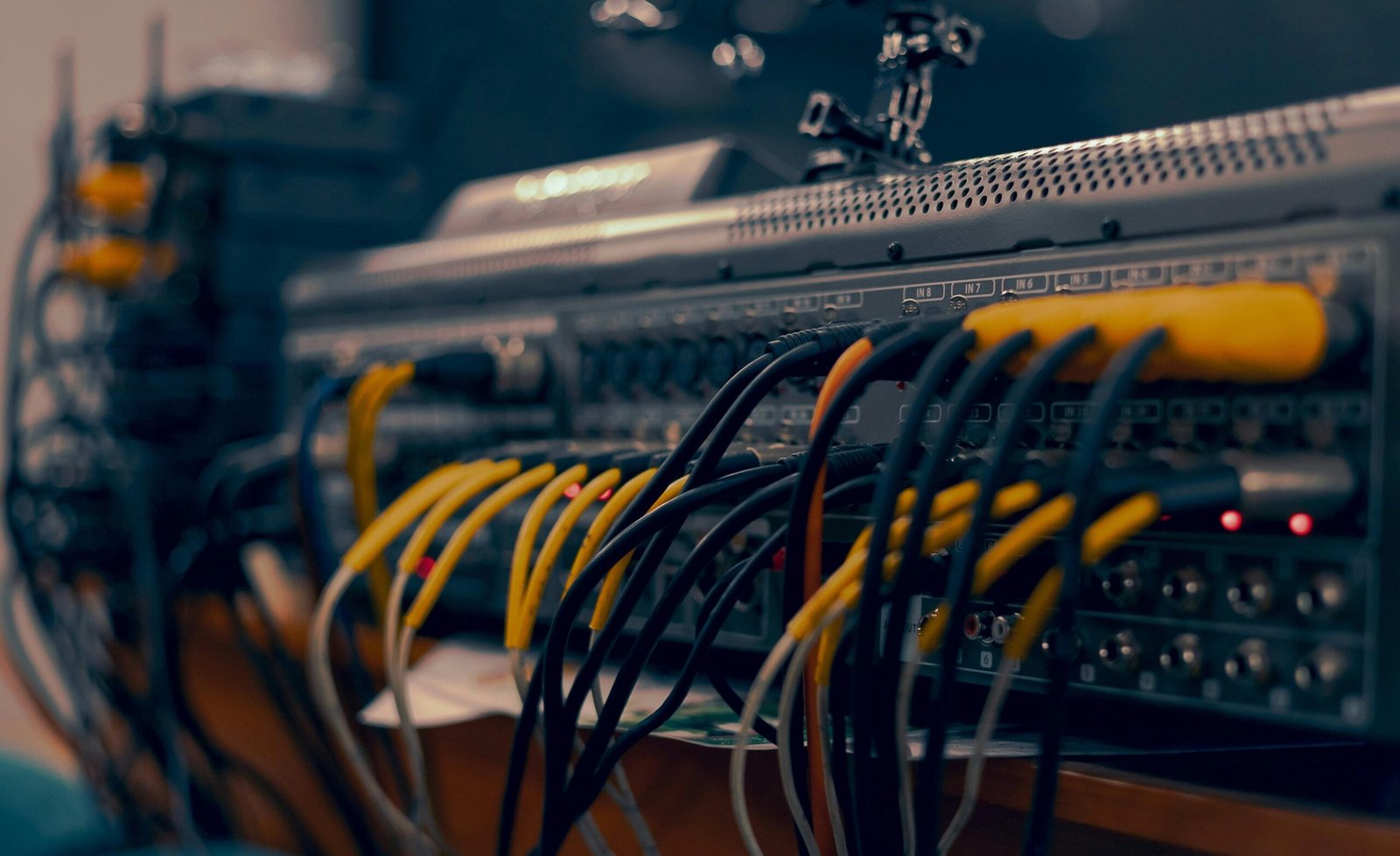 Audio mixer connected with multiple cables in a professional setup.