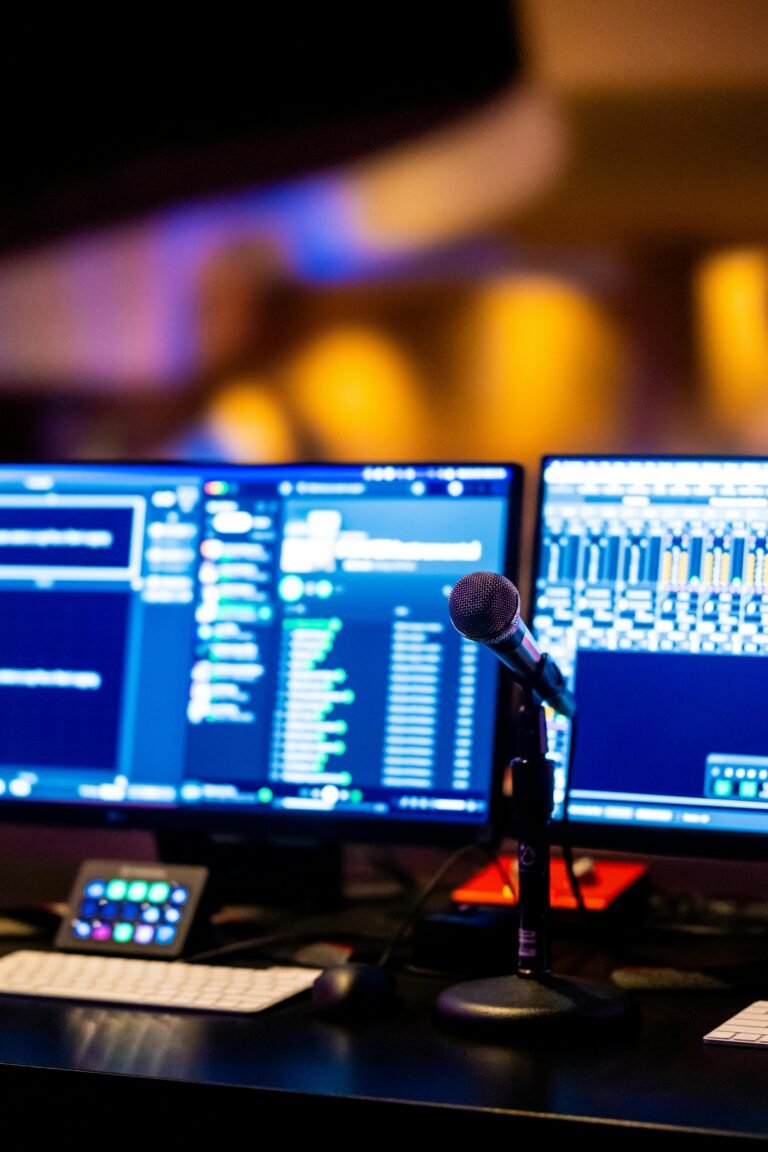 A modern studio setup featuring dual monitors and a microphone for professional music production.