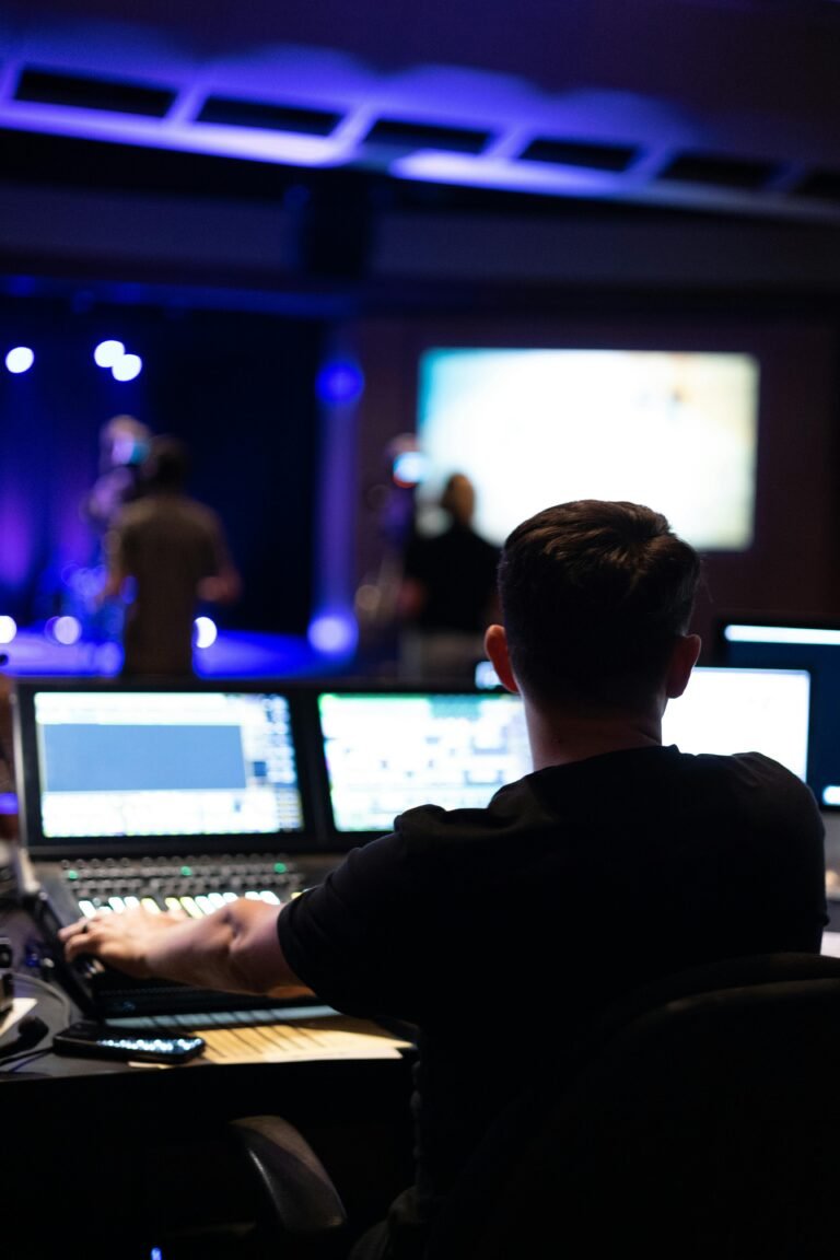Sound engineer working at mixing console during a live studio performance.